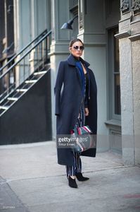 olivia-culpo-is-wearing-a-coat-from-ports-1961-stripe-pants-from-picture-id510113604.jpg