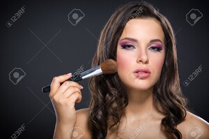 22529315-Portrait-de-la-belle-fille-d-appliquer-le-maquillage-lumineux-rose-sur-fond-gris-Concept-de-la-beaut-Banque-d'images.jpg